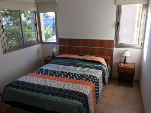 1 dormitorio con 2 camas y 2 ventanas en Solares Apart en Las Gaviotas