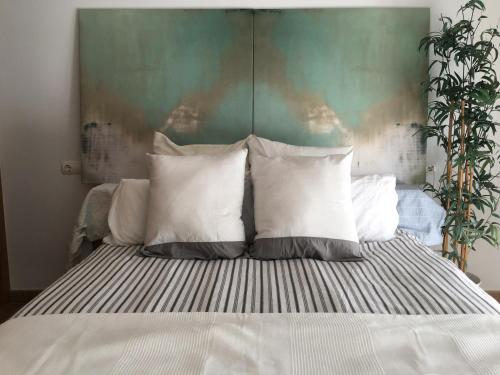 Una cama con almohadas blancas y un cabecero verde. en alquilaencanarias El Medano Sotavento, Great Terrace and beach, en El Médano