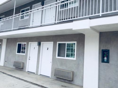 - un bâtiment avec deux portes blanches et un balcon dans l'établissement Value Inn, à Sylmar