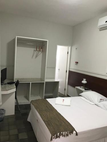 Schlafzimmer mit einem Bett, einem Schreibtisch und einem Spiegel in der Unterkunft Hotel Velho Monge in Teresina