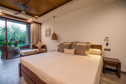 a bedroom with a large bed and a large window at Hoi An Eco Lodge & Spa in Hoi An