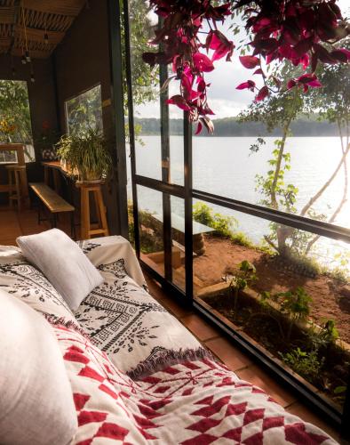 a bed in a room with a view of the water at The Lake House Dalat in Da Lat