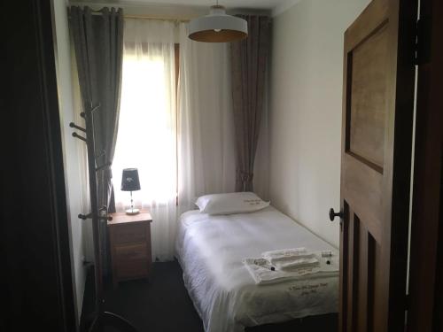 a small bedroom with a bed and a window at Te Puia Hot Springs Hotel in Te Puia