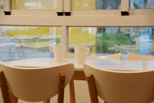 a white table with chairs and a window at Trip Village-Taitung Trip in Taitung City