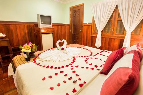 a bed with a wedding dress on top of it at Siem Reap Center Hotel in Siem Reap