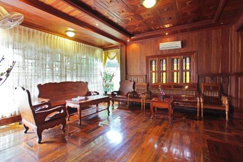 a large living room with wooden floors and benches at Hima Boutique in Siem Reap
