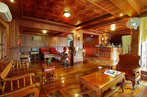 a large living room with wooden floors and wooden furniture at Siem Reap Center Hotel in Siem Reap