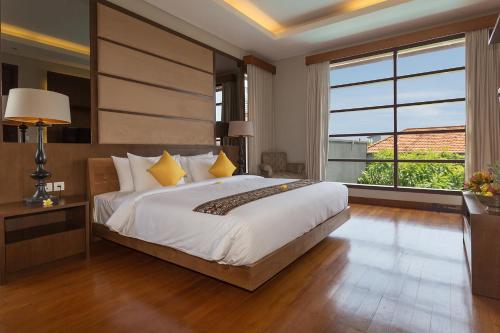 a bedroom with a large bed and a large window at Entrada Seminyak Villa By Nagisa Bali in Seminyak