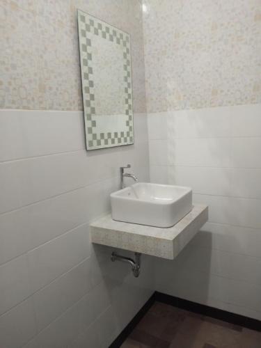 a bathroom with a sink and a mirror on the wall at Tirta Yoga Inn in Padangbai