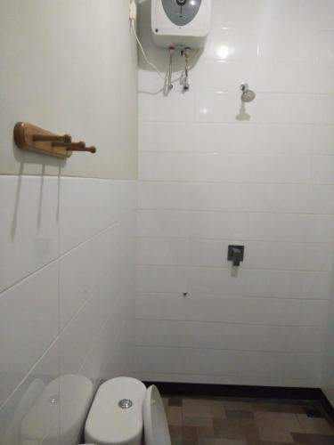 a bathroom with a toilet and a phone on the wall at Tirta Yoga Inn in Padangbai