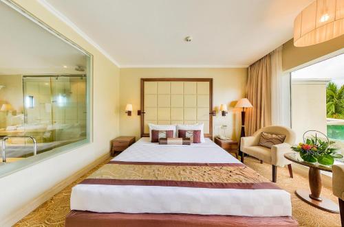 a hotel room with a large bed and a bathroom at Sea Links Beach Hotel in Mui Ne