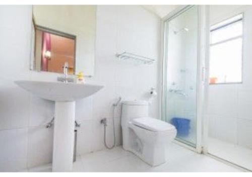 4Bhk Exotic Villa with Swimming pool في آربورا: حمام أبيض مع حوض ومرحاض
