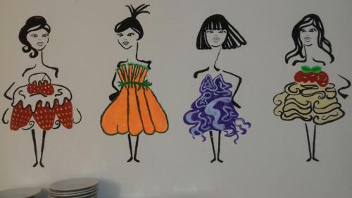 a wall with four drawings of women in dresses at Hotel Marylise in Rimini