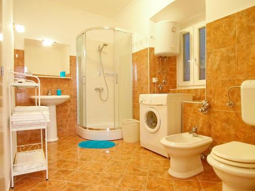 y baño con ducha, aseo y lavadora. en Apartment Kameo with terrace, en Dubrovnik