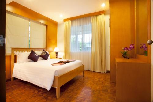 una camera con un grande letto e una finestra di Villa with private pool a Hua Hin