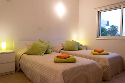 two beds in a room with a window at Eden Beach Apartment 207 in Limassol