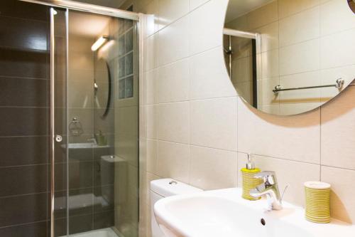 a bathroom with a shower and a sink and a mirror at Eden Beach Apartment 207 in Limassol