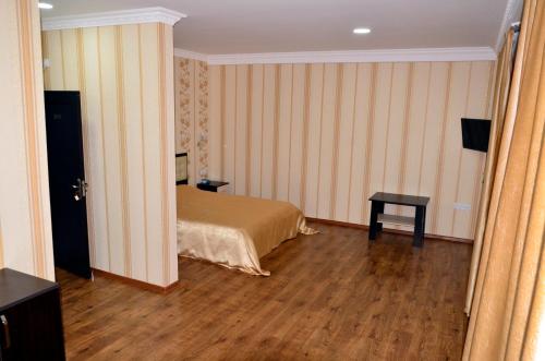 a bedroom with a bed and a table in it at KavKaz Hotel & Restaurant in Marneuli