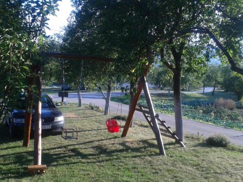a swing set in a park with a car at Guest House Adrijana in Seliste Dreznicko
