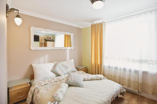 a bedroom with a bed with a mirror and a window at Pokoje Gościnne Gazda in Polanica-Zdrój