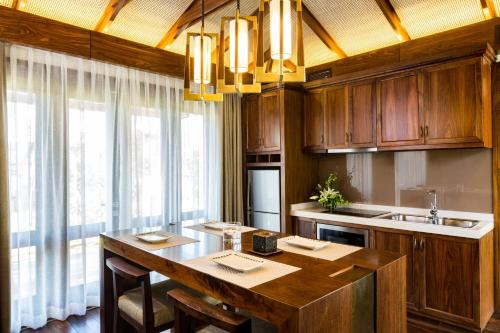 a kitchen with a large wooden table and a sink at Duyen Ha Resort Cam Ranh in Cam Ranh