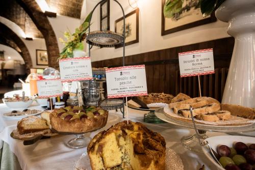 a table with different types of pastries and pies at Hotel Aganoor in Castiglione del Lago