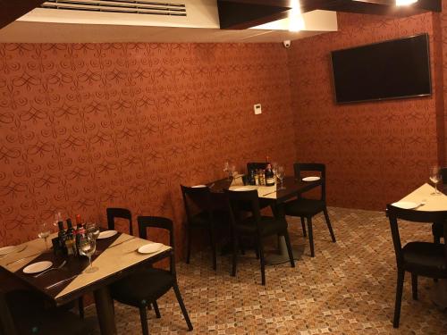 a dining room with tables and chairs and a flat screen tv at Hotel Sommelier Boutique in Santiago
