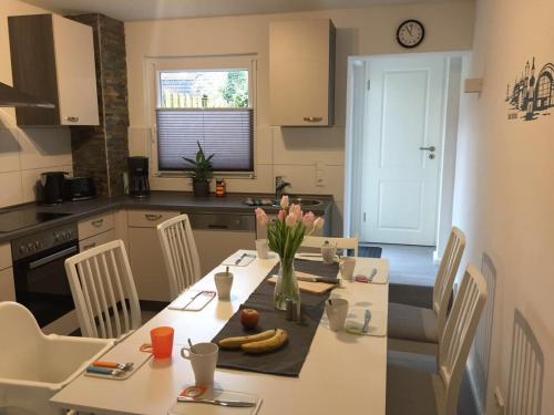 eine Küche mit einem Tisch und einer Blumenvase darauf in der Unterkunft Ferienhaus Kluntje in Emden