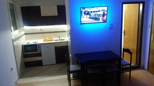 a small kitchen with a table and a blue wall at KOPAONIK-GONDOLA 100m in Brzeće