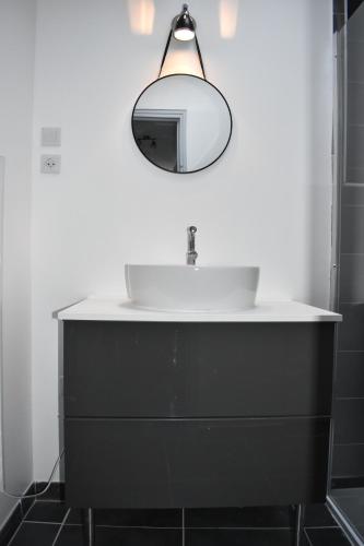 une salle de bain avec un lavabo et un miroir dans l'établissement Les Gîtes de Laure - L'Or Vert, Appartement avec Vue sur le Château, Parking Privé, Climatisation, Netflix, à 160 m de la Cité Médiévale, à Carcassonne