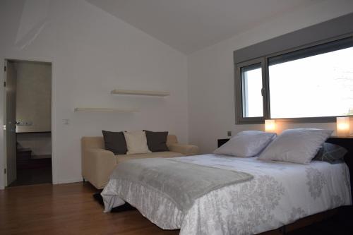 a bedroom with a bed and a couch and a window at Villa Cristal in La Orotava