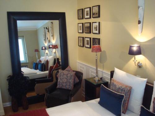 a bedroom with a mirror and a bed and a chair at Hotel Sir & Lady Astor in Düsseldorf