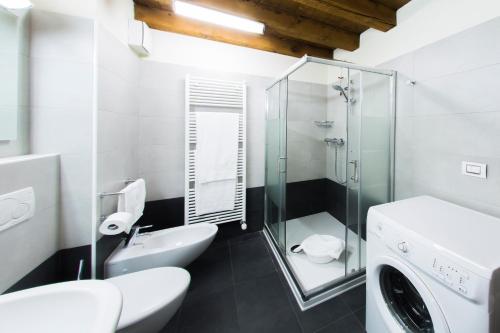 La salle de bains est pourvue de toilettes et d'une douche en verre. dans l'établissement Arena Dreams Apartment, à Vérone