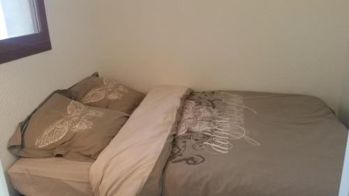 un lit avec deux oreillers dessus dans une chambre dans l'établissement Résidence Cap Azur Appartement 228, à Villeneuve-Loubet