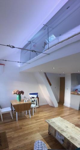 a living room with a table and a skylight at The Sail Loft - Hayling Island in South Hayling