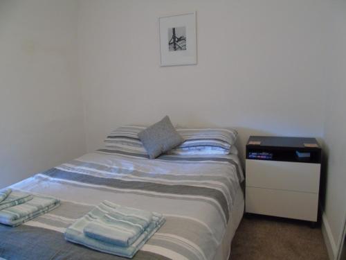 へレンズバラにあるSnug - Krayr Apartmentのベッドルーム1室(ベッド1台、タオル2枚付)