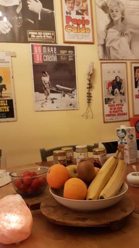 una ciotola di banane, arance e altra frutta su un tavolo di Bellini Apartment a Catania