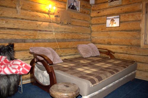 ein Schlafzimmer mit einem Bett in einem Blockhaus in der Unterkunft Хатина біля потока in Lumshory