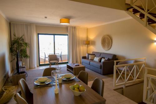 a living room with a table and a couch at Pestana Gramacho Residences in Ferragudo