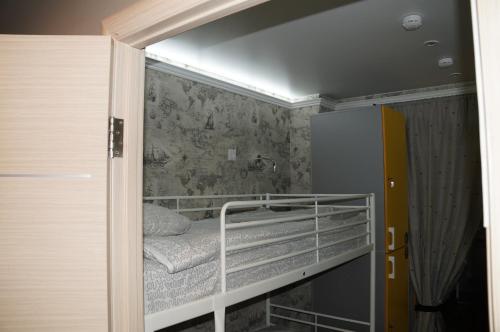 a small room with a bunk bed and a refrigerator at Хостел Обской возле Толмачево in Ob