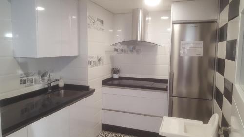 a kitchen with a stainless steel refrigerator and a sink at Deluxe Hostels & Suites Merida in Merida