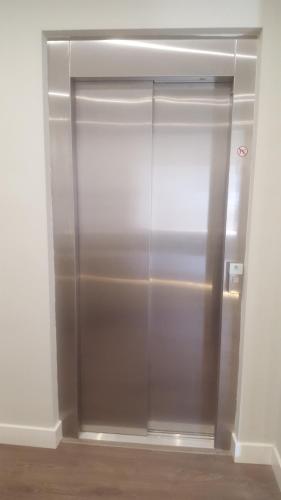 a stainless steel elevator in an empty room at Deluxe Hostels & Suites Merida in Merida