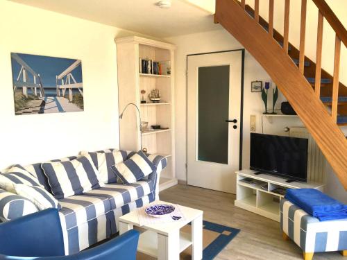 a living room with a couch and a television at Ferienwohnung Meisennest in Cuxhaven