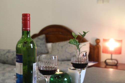 a bottle of wine and two glasses on a table at Natures Bliss Holidays in Ja-Ela