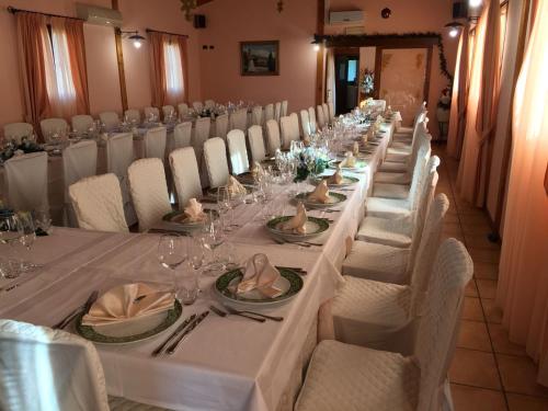 a long table with white tables and chairs in a room at Case Vacanza Fiocchi in Arrone