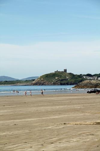 a group of people walking on the beach at Aberdunant Hall Holiday Park in Porthmadog