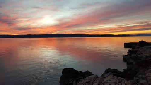 a sunset over a large body of water at Apartments Adriatic in Selce