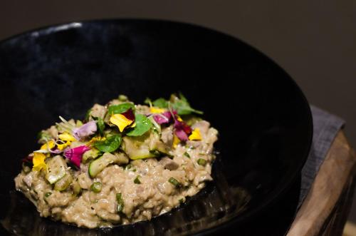 a black bowl of food with vegetables in it at Summerfields Rose Retreat and Spa in Hazyview