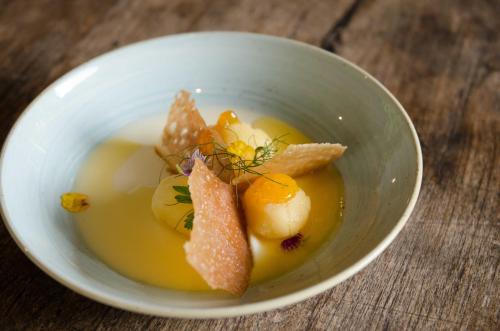 a bowl of soup on a wooden table at Summerfields Rose Retreat and Spa in Hazyview