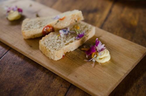 a cutting board with two slices of bread and a flower at Summerfields Rose Retreat and Spa in Hazyview